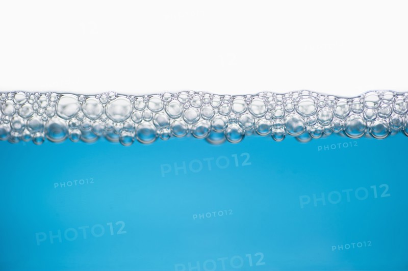 Close up of soap bubbles on water surface.