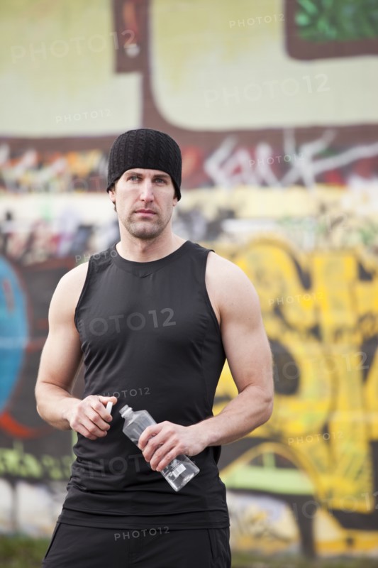 USA, Washington, Seattle, man in workout wear in front of graffiti wall. Photo : Take A Pix Media
