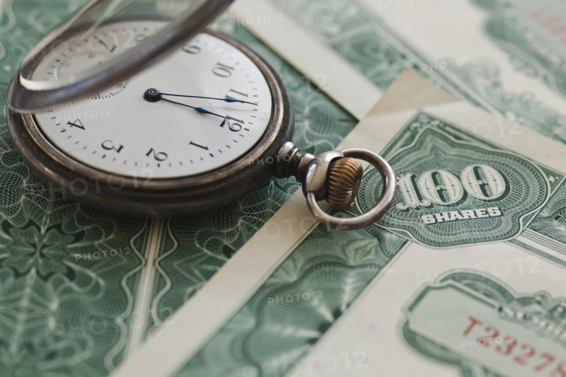 Close up of pocket watch and shares.