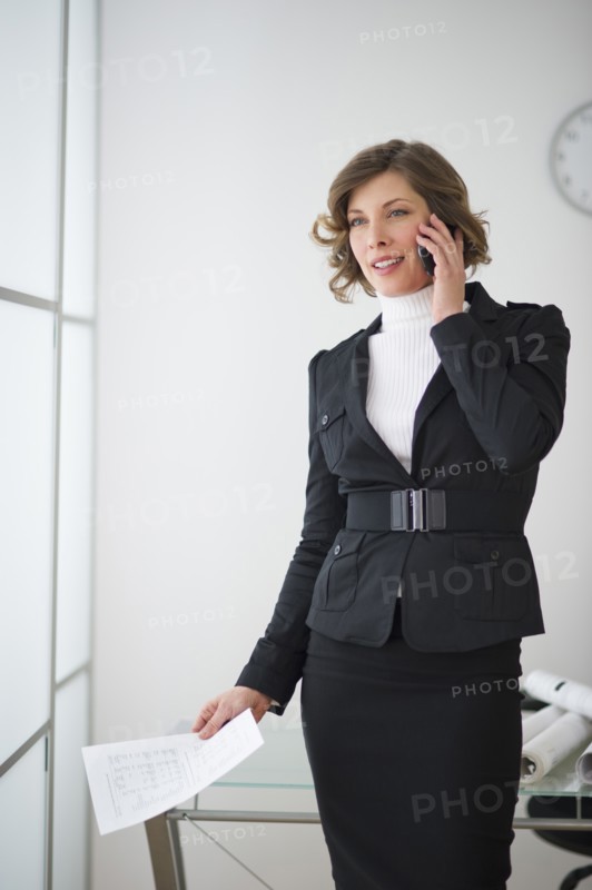 Businesswoman talking on mobile in office.