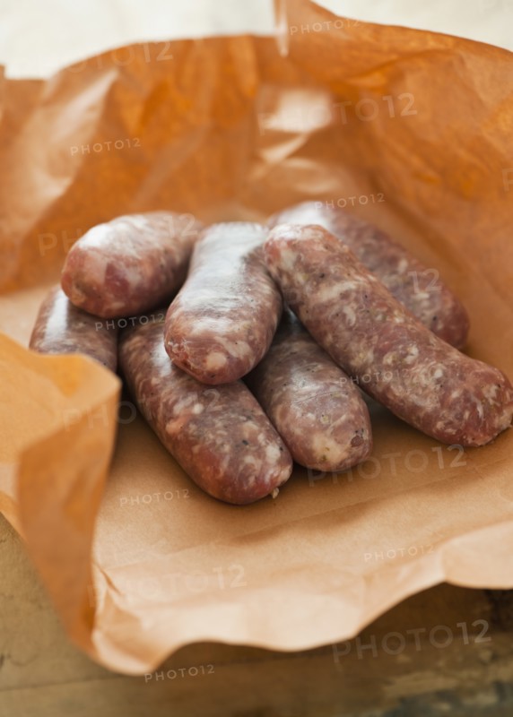 Studio shot of sausage wrapped in brown paper.