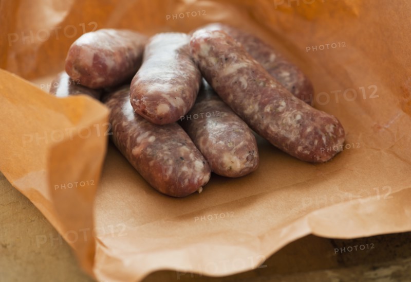 Studio shot of sausage wrapped in brown paper.
