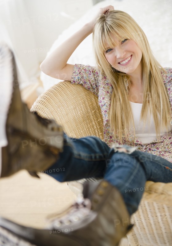 Young woman sitting in wicker chair. Photo: Jamie Grill Photography