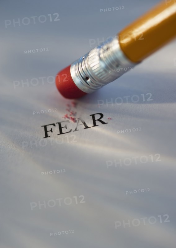 Studio shot of pencil erasing the word fear from piece of paper. Photo: Daniel Grill