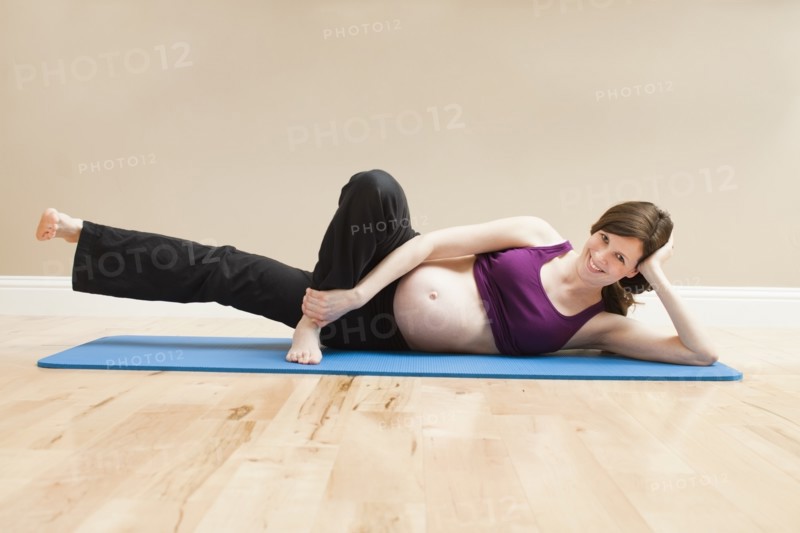 Young pregnant woman exercising. Photo : Mike Kemp