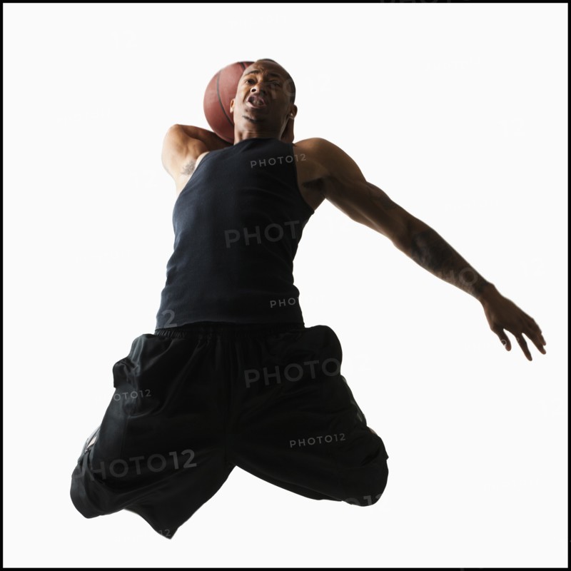 Studio shot of young man playing basketball. Photo : Mike Kemp
