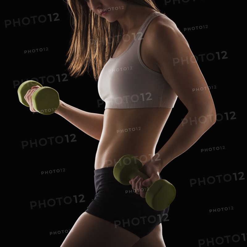 Young woman using hand weights. Photo : Mike Kemp