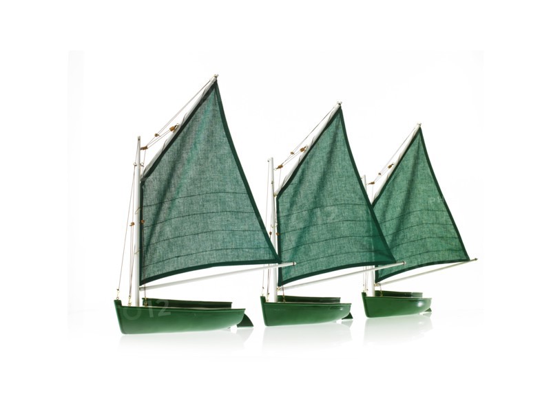 Row of toy boats on white background. Photo : David Arky