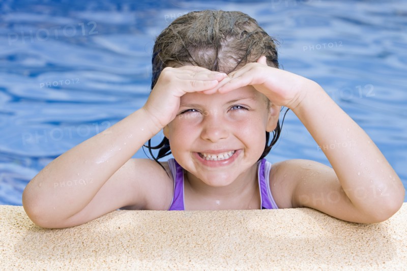 Portrait of smiling girl (6-7) in swimming pool. Photo: Justin Paget