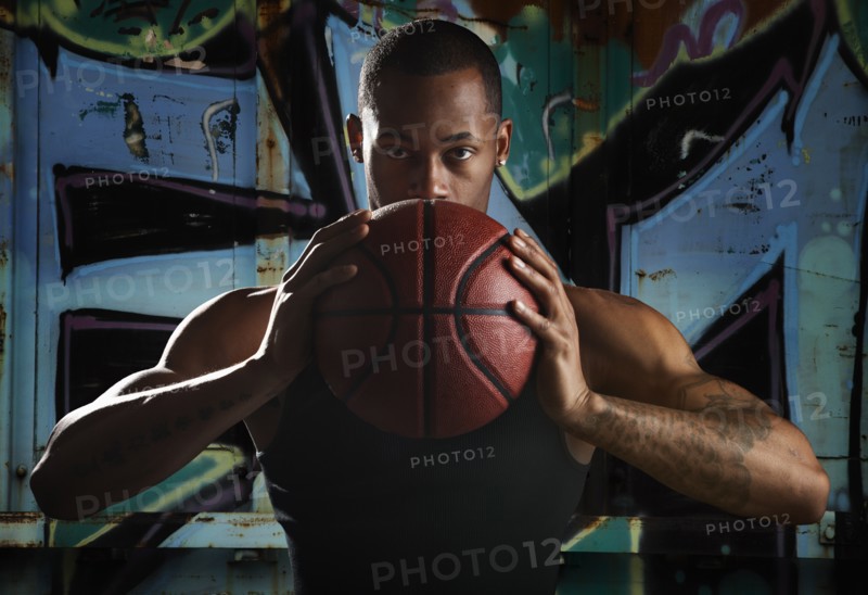 Portrait of young man with basketball. Photo: Mike Kemp