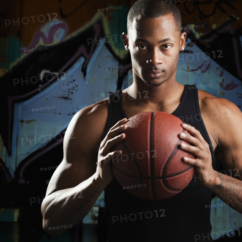 Portrait of young man with basketball. Photo : Mike Kemp