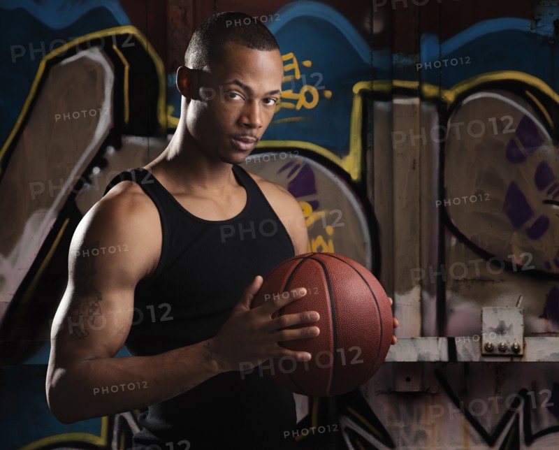 Portrait of young man with basketball. Photo : Mike Kemp