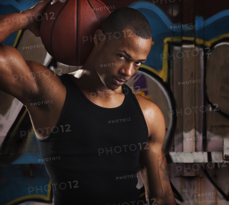 Portrait of young man with basketball. Photo : Mike Kemp