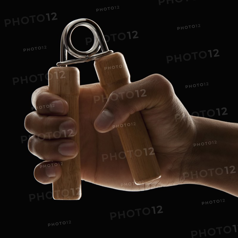 Studio shot of young man's hand exercising. Photo : Mike Kemp