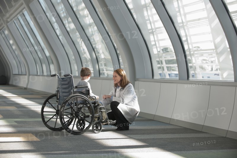 Female doctor talking to boy (6-7) in wheelchair. Photo: Mark Edward Atkinson