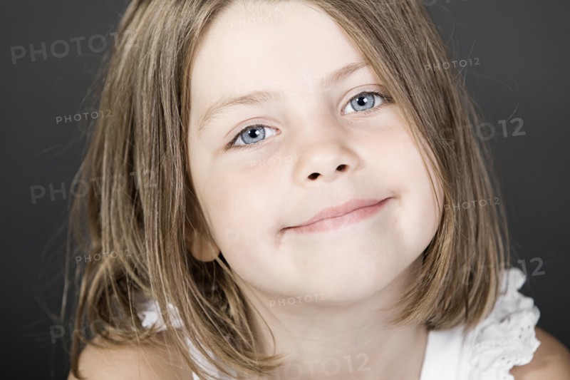 Studio portrait of smiling girl (6-7). Photo : Justin Paget