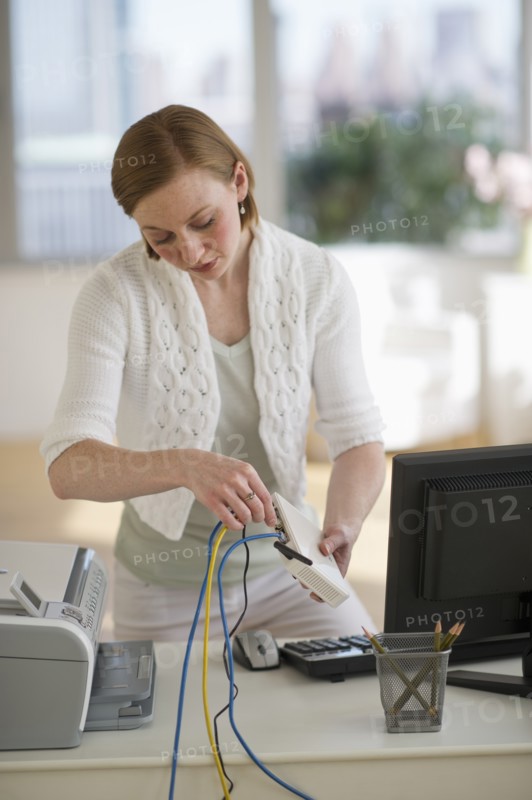 Woman installing router at home office.