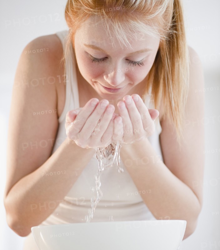 Woman washing face. Photo : Jamie Grill Photography