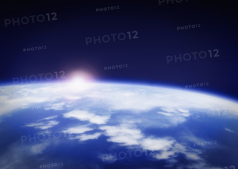 Space with rising sun above planet earth.