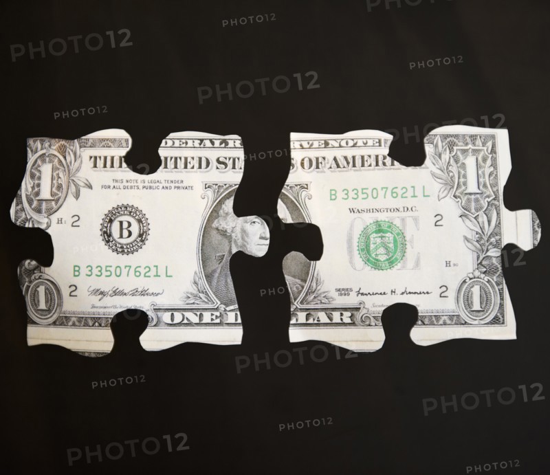Studio shot of jigsaw pieces depicting one dollar bill. Photo : Jamie Grill Photography