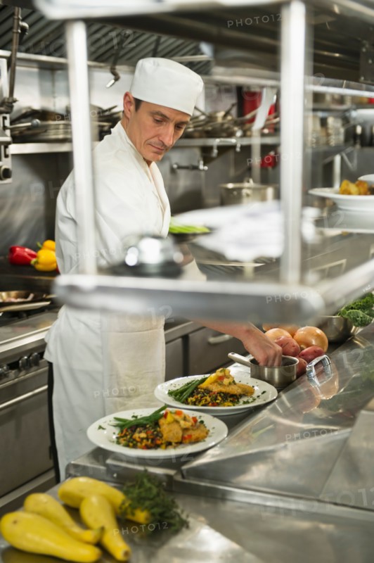 Chef preparing food in kitchen.