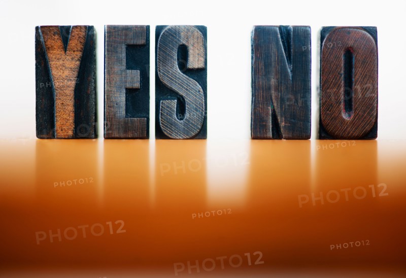 Wooden letter blocks spelling 'yes' and 'no', studio shot.