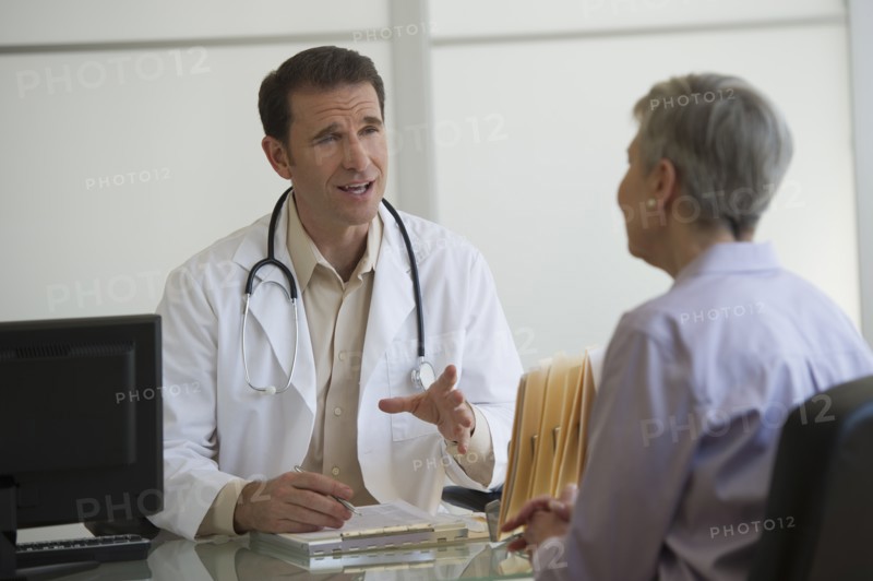 Doctor and female patient sitting in office.