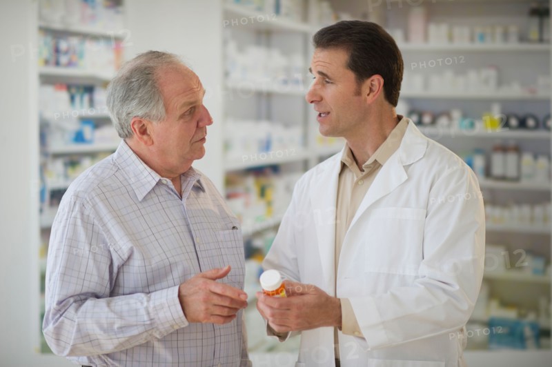 Pharmacist explaining use of medicine to patient.
