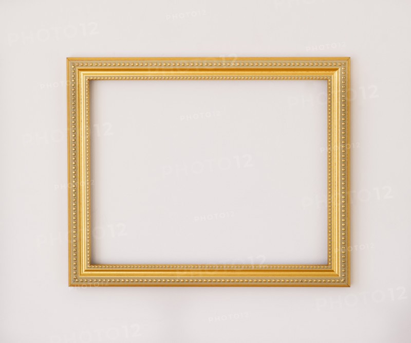 Studio shot of golden picture frame on white background. Photo : Daniel Grill