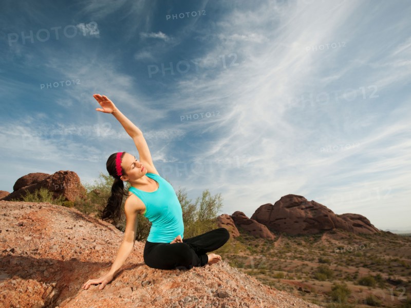 USA, Arizona, Phoenix, Young woman practicing yoga on desert.