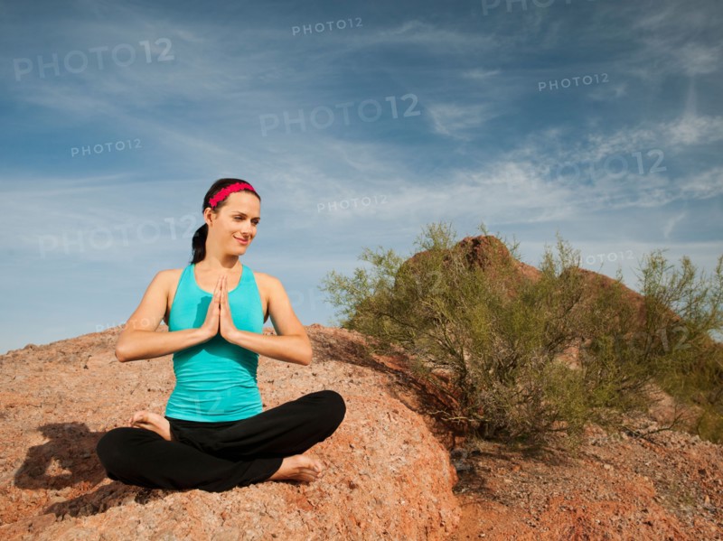 USA, Arizona, Phoenix, Young woman practicing yoga on desert.