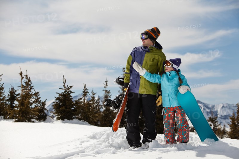 USA, Colorado, Telluride, Father and daughter (10-11) standing with snowboards in winter scenery. Photo : db2stock