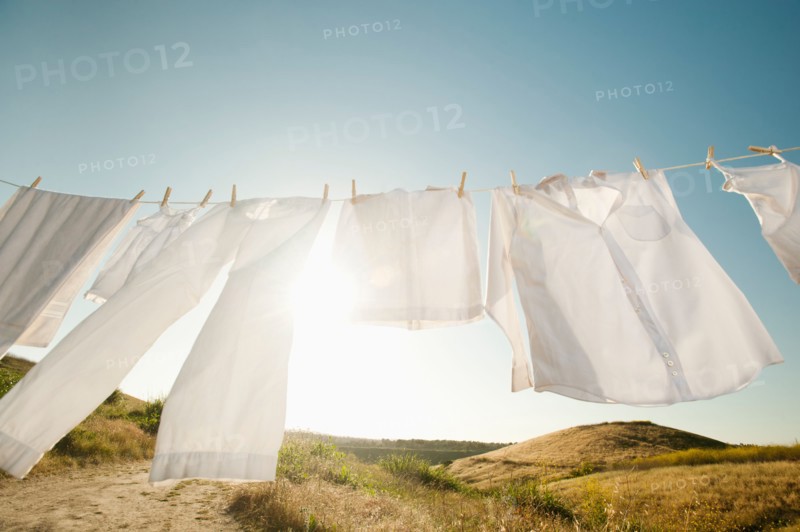 Laundry hanging on clothesline against blue sky.