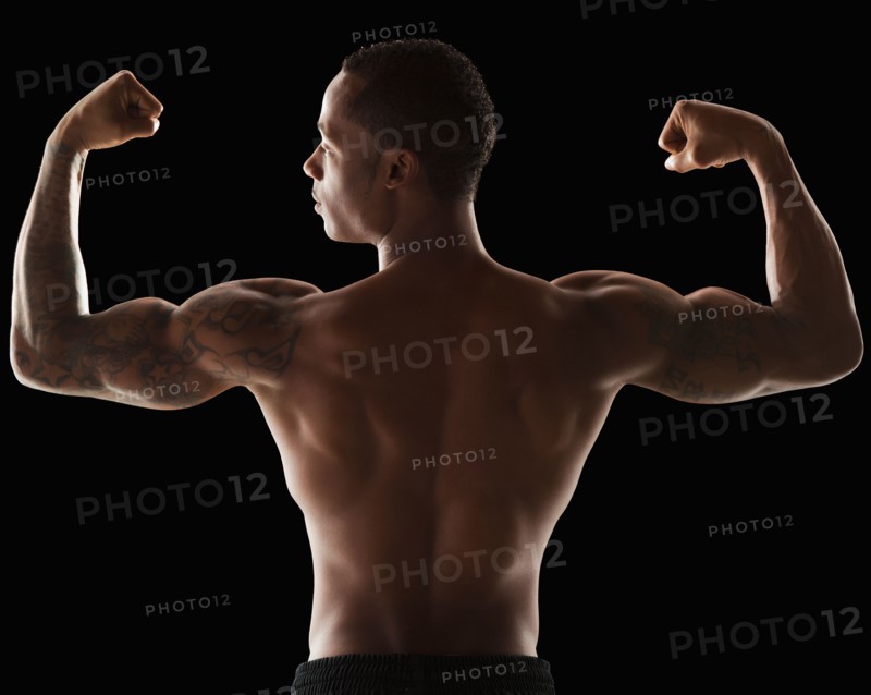 Rear view of muscular man flexing muscles. Photo : Mike Kemp