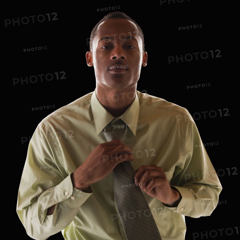 Businessman tying tie. Photo : Mike Kemp