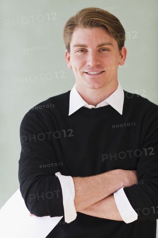 portrait of young teacher standing in front of blackboard. Photo : Daniel Grill