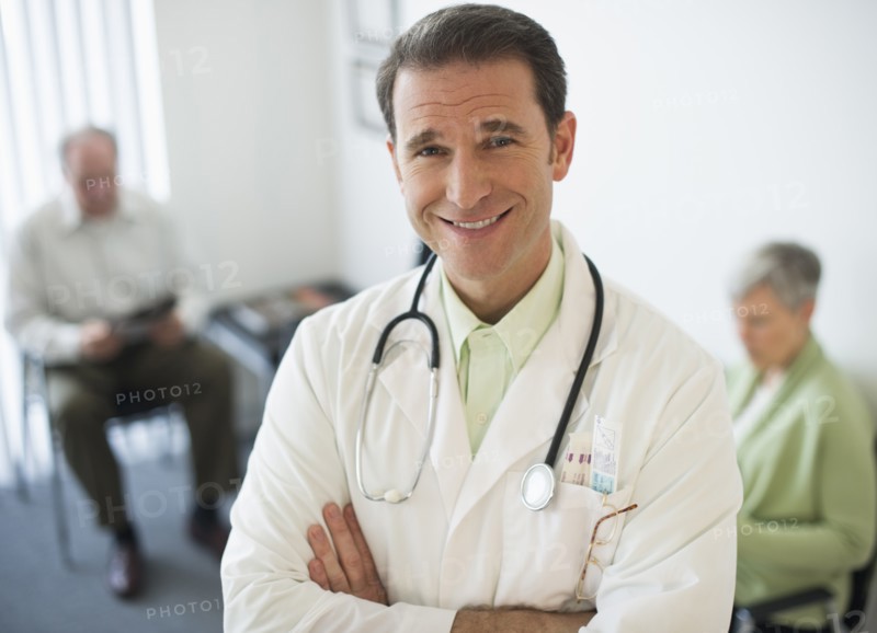 Portrait of doctor, senior couple in the background.