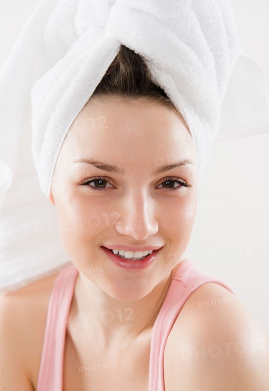 Studio portrait of smiling young woman with towel turban. Photo : Jamie Grill Photography