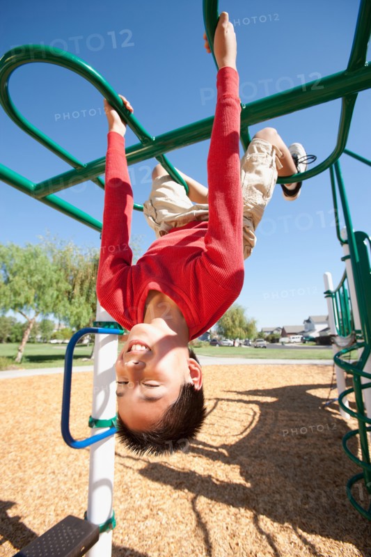 USA, California, Boy (12-13) climbing at playground. Photo : Noah Clayton