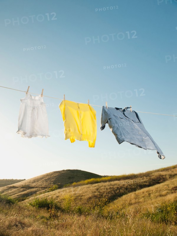 Laundry hanging on clothesline against blue sky.