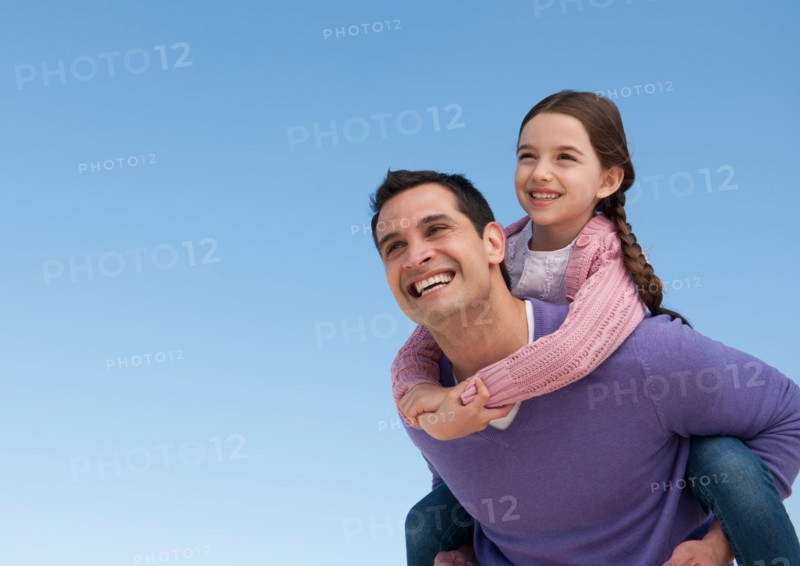 Father giving piggyback ride to daughter (8-9).