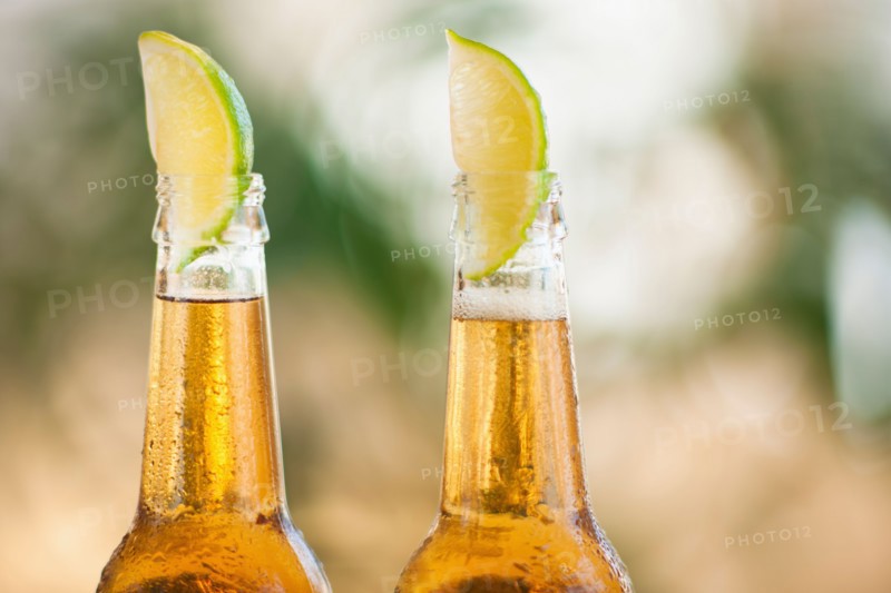 Two beer bottles with lime wedges.