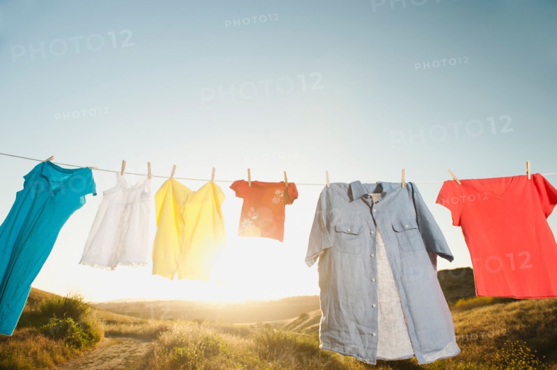 Laundry hanging on clothesline against blue sky.