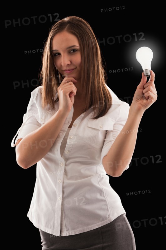 Young attractive businesswoman holding illuminated bulb. Photo : Mike Kemp