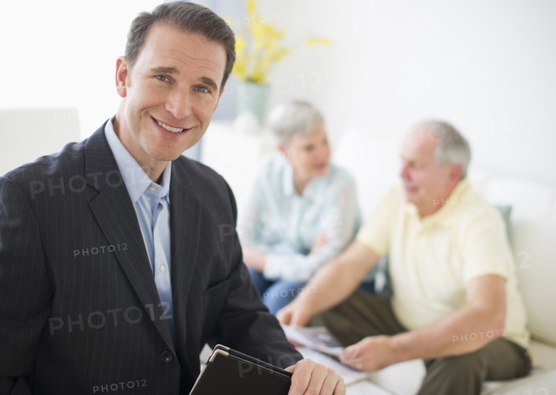 Portrait of businessman, senior couple in the background.