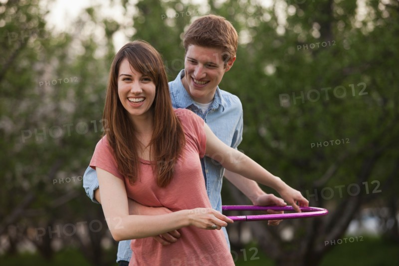 Young couple using plastic hoop in orchard. Photo : Mike Kemp