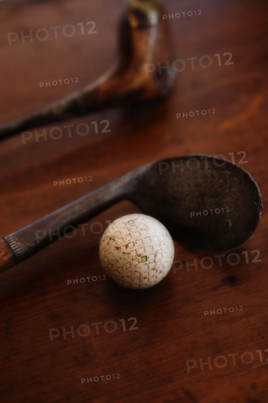 Close up of antique golf clubs and golf ball.