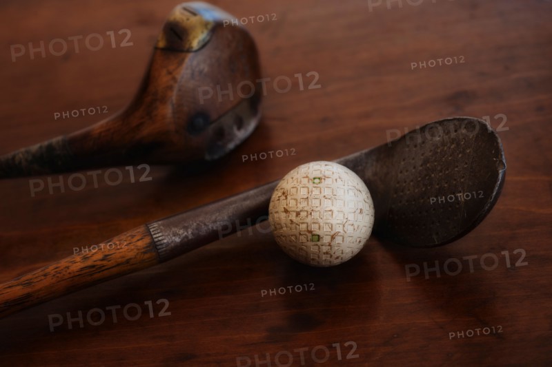 Close up of antique golf clubs and golf ball.