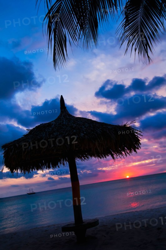 Aruba, silhouette of palapa on beach at sunset. Photo : Daniel Grill