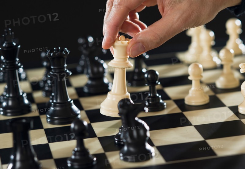 Close-up of man's hand playing chess.